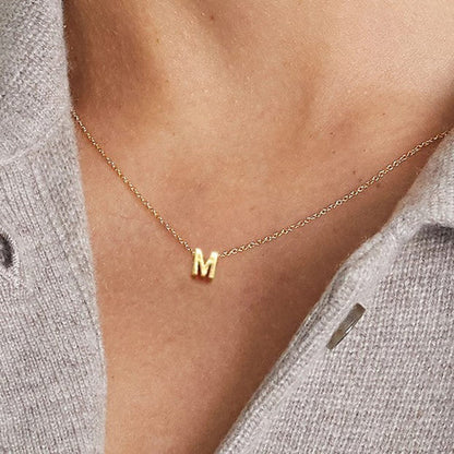 Tiny Initial Necklace with a delicate chain and small personalized letter charm.

